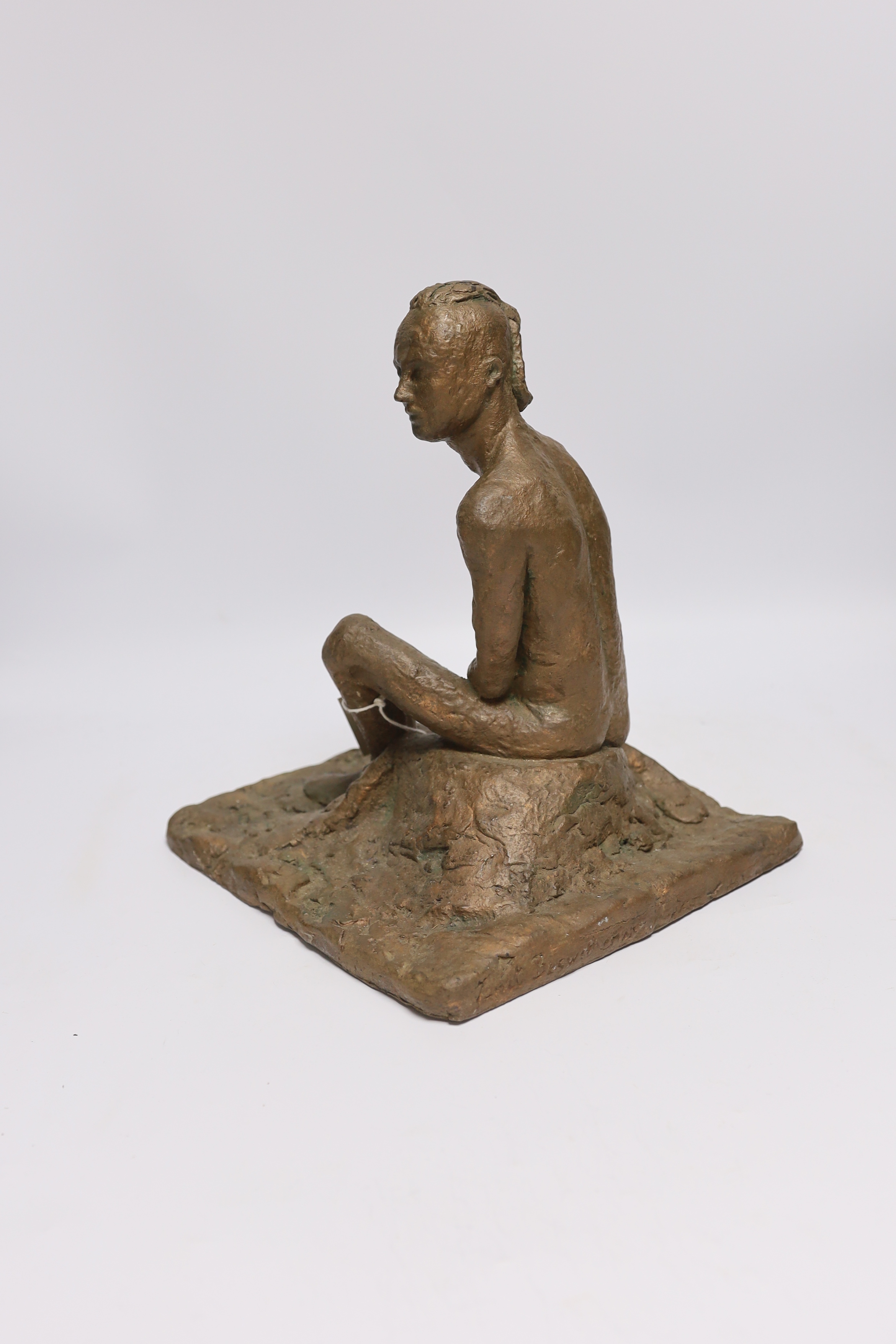 An abstract bronzed resin sculpture of a kneeling man, 30cm